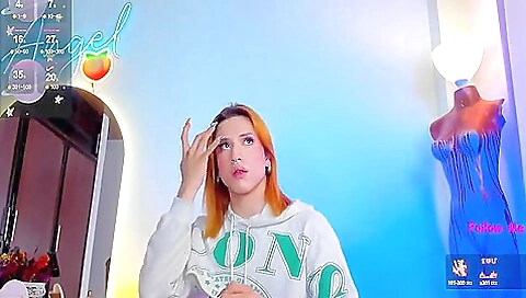 A brunette with a red head and tattoo is riding a dildo